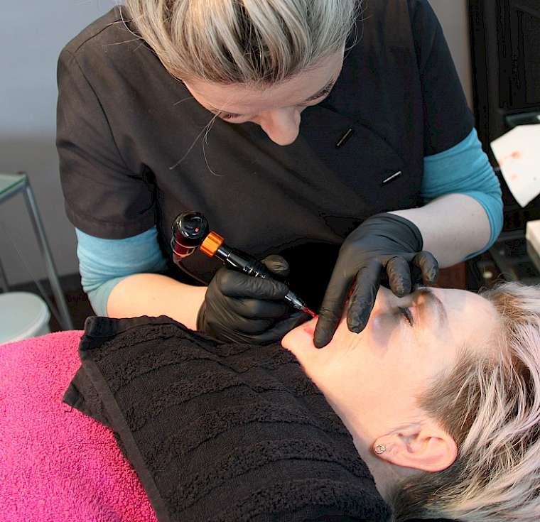 Schülerin beim Permanent-Make -up Lippe am Model Bild Permanent-Make-up Seminar